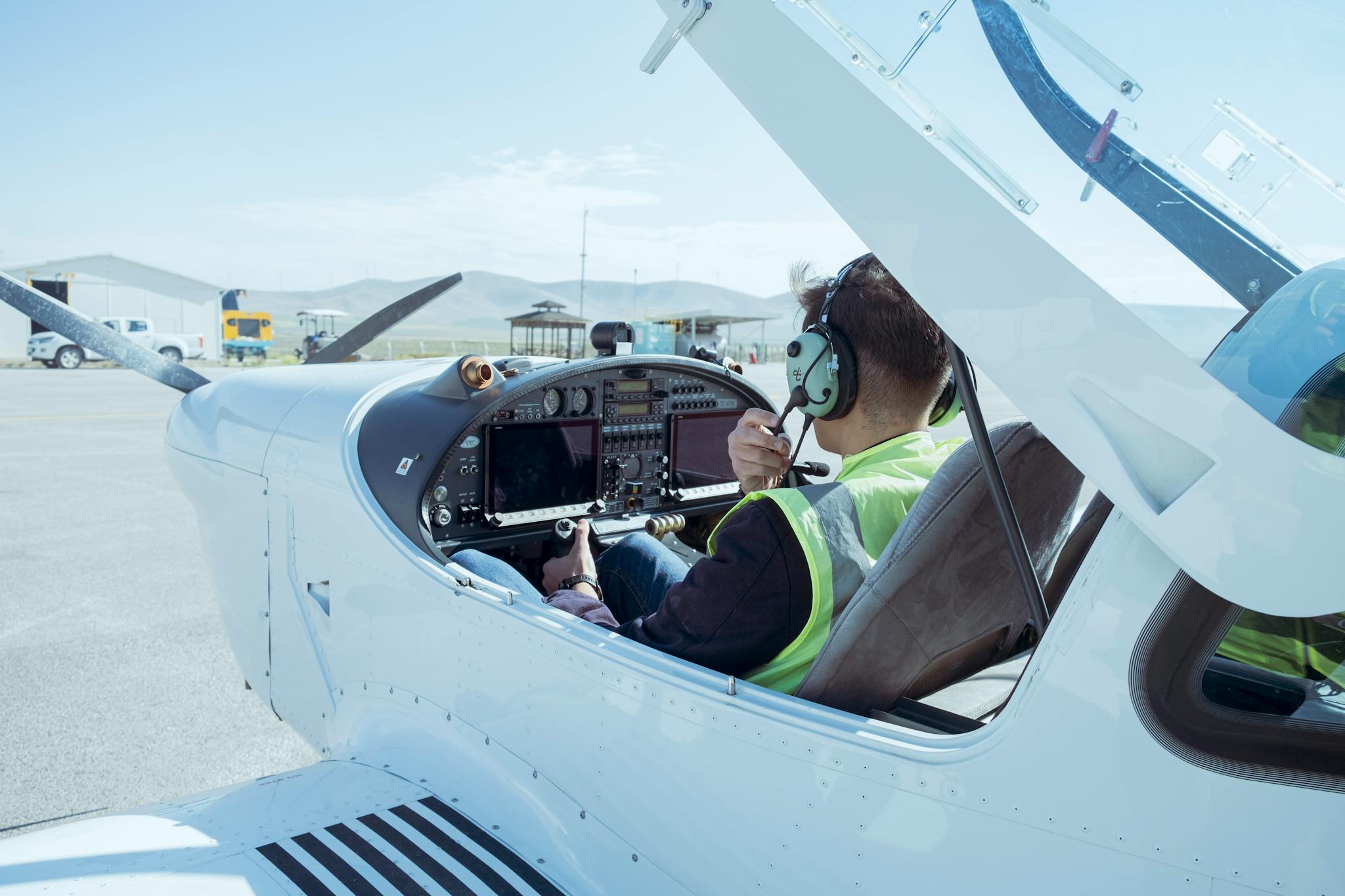 A pilot in the cockpit of a small aircraft readying for flight at Konya Airport, T&uuml;rkiye.