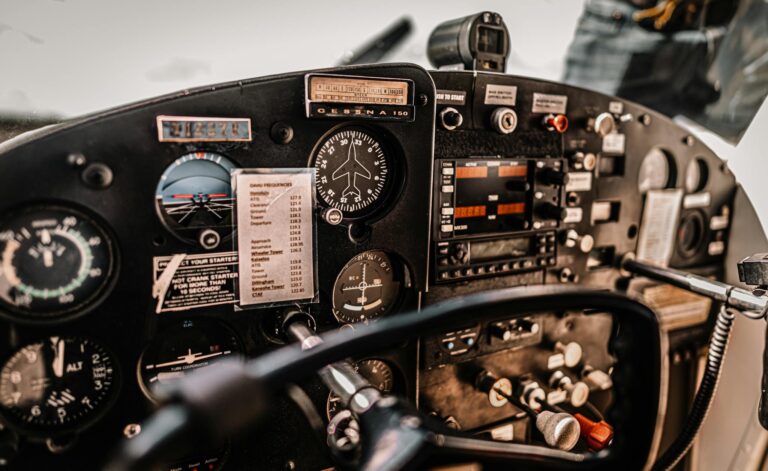 Control dashboard and yokes in cockpit of small light airplane parked in airfield